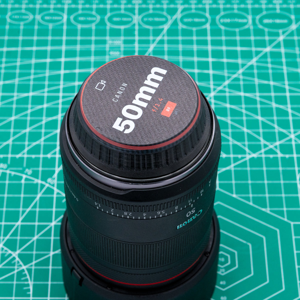 A row of custom UV-printed camera lens caps with different production company logos